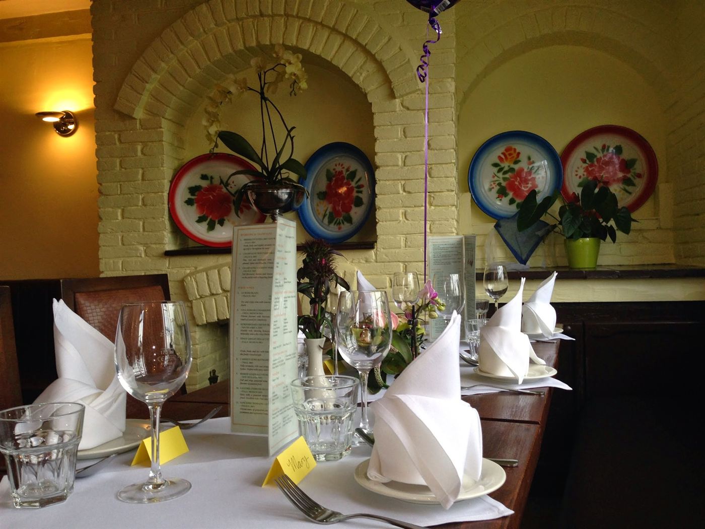 Inside Tom Yum: tables laid under the arch with painted Thai plates