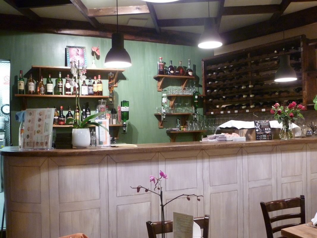 The bar with green walls and a wine rack