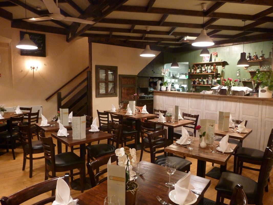 The dining room laid for dinner, with the bar at the back