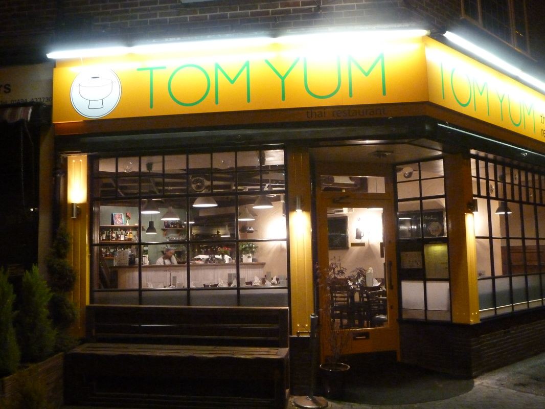 The Tom Yum shopfront lit up in the evening